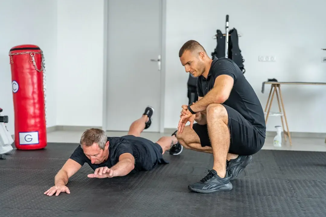 Bilan sportif à Bourgoin-Jallieu : un coach Get Your Move observe un client au sol