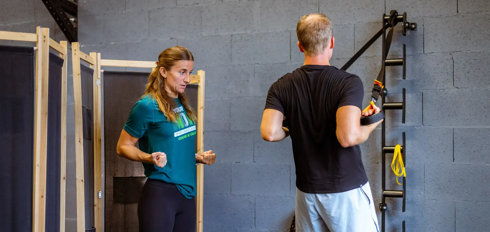 Coach Get Your Move guidant un client aux sangles de suspension au studio de Bourgoin-Jallieu