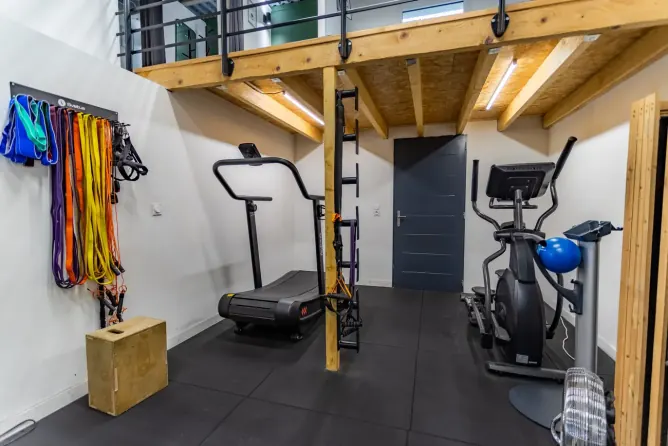 Coin cardio sous la mezzanine avec tapis de course, vélo elliptique et élastiques chez Get Your Move