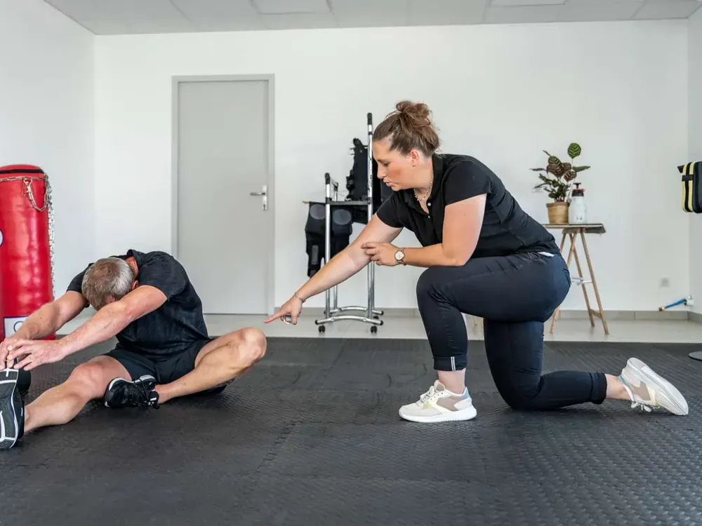 Client en étirement de l'arrière des cuisses guidé par une coach Get Your Move