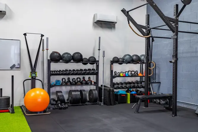 Rack de médecine-balls, kettlebells et haltères au studio Get Your Move à Bourgoin-Jallieu