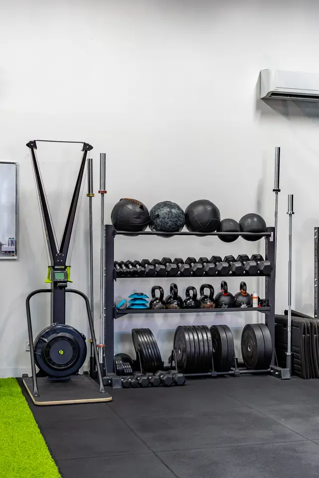 SkiErg, disques et kettlebells rangés au studio Get Your Move