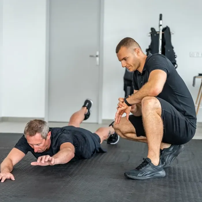 Coach Get Your Move observant un client au sol pendant un bilan sportif